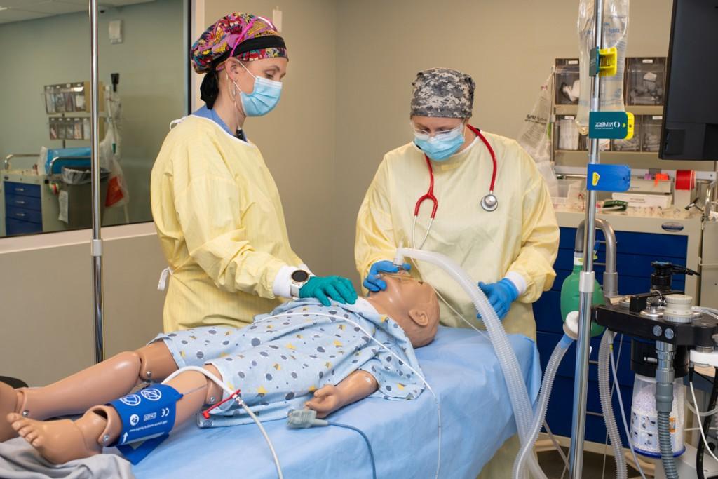 Two U N E Nursing Anesthesia students practice giving a simulation dummy anesthesia